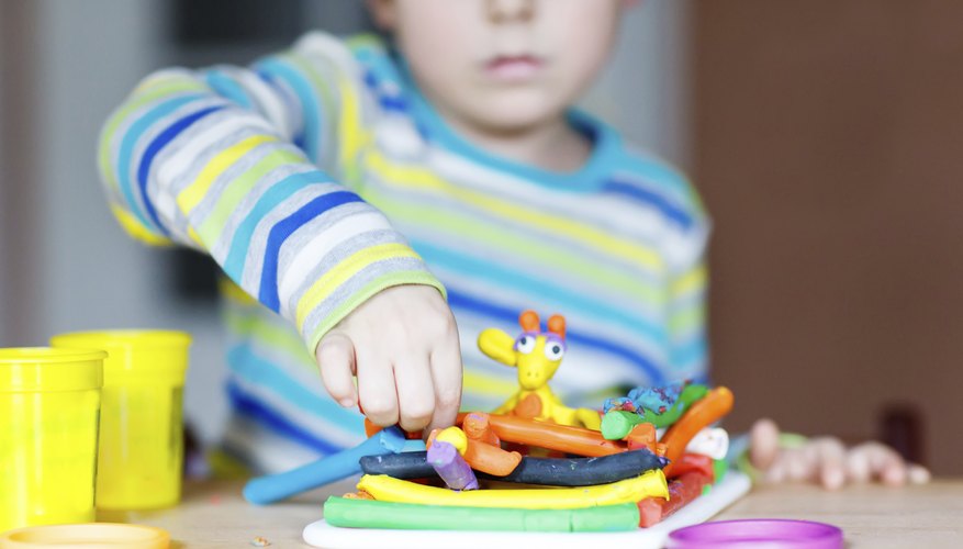 A young boy playing with colorful modeling clay.