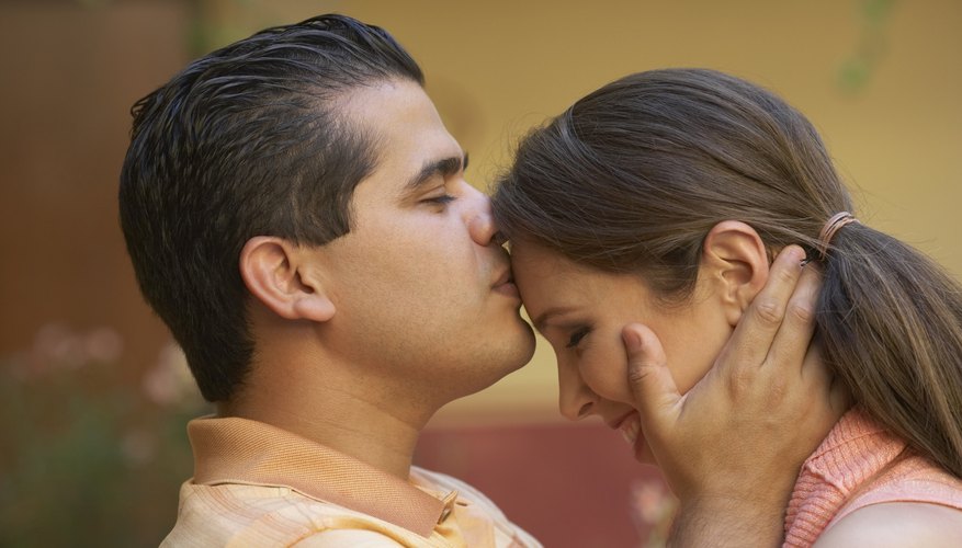 Man kissing woman on forehead
