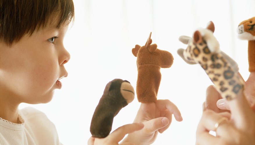 Young child playing with finger puppets.
