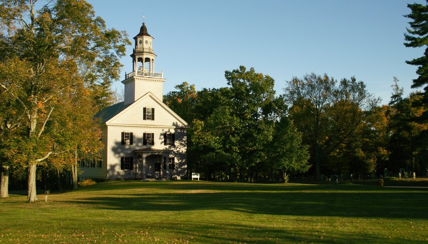A small church surrounded by trees.