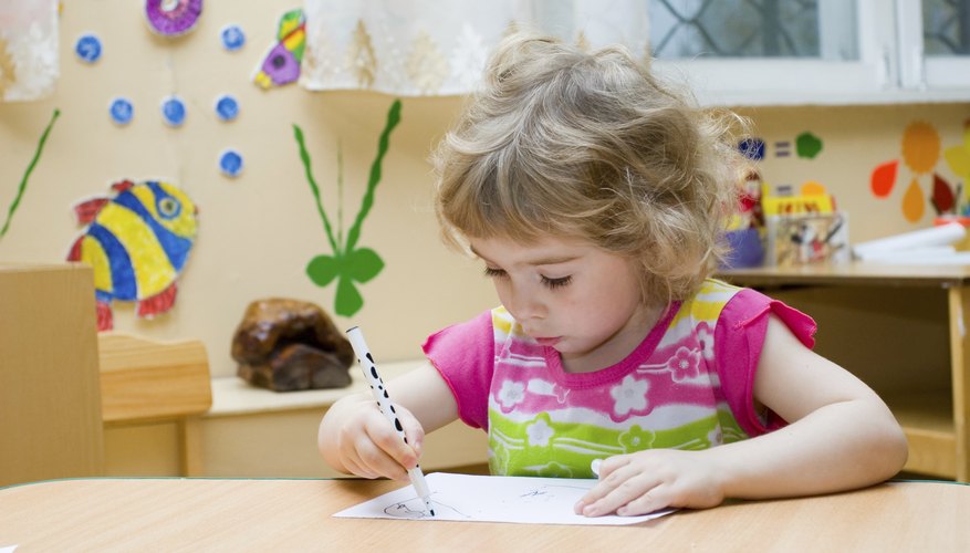 Preschooler coloring at desk.
