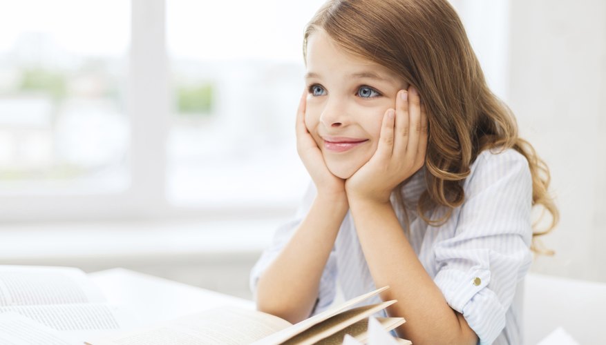 Child smiling in front of book