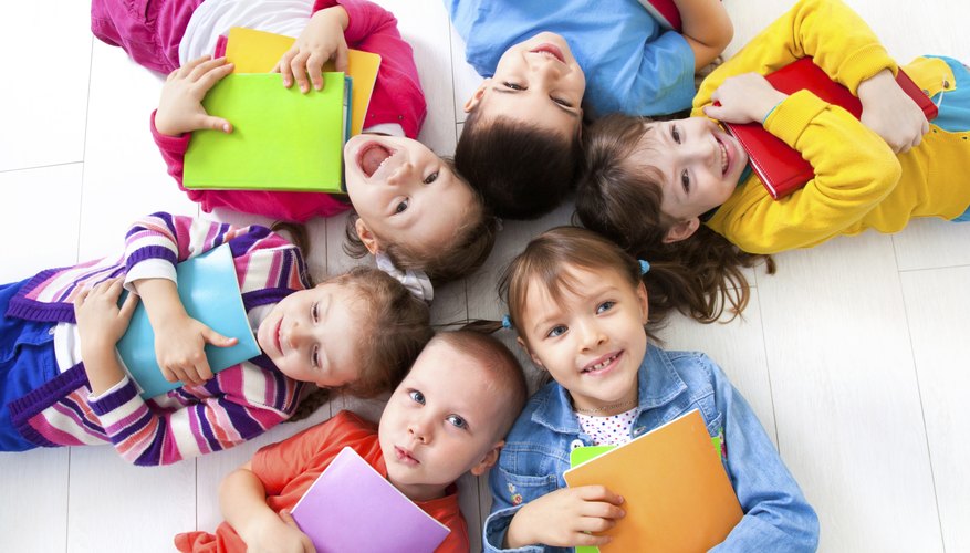 Smiling circle of preschool students lying on the floor