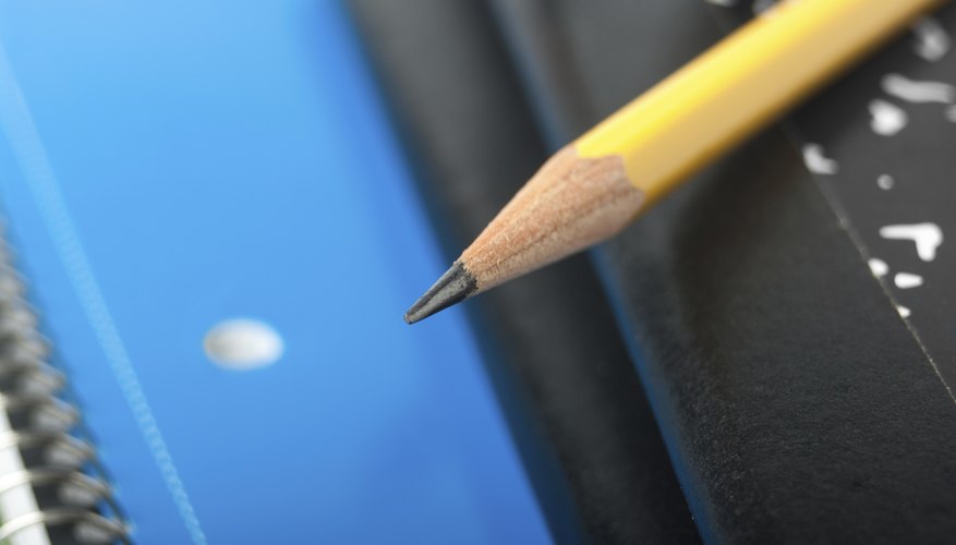 Close-up of pencil sitting on top of notebooks