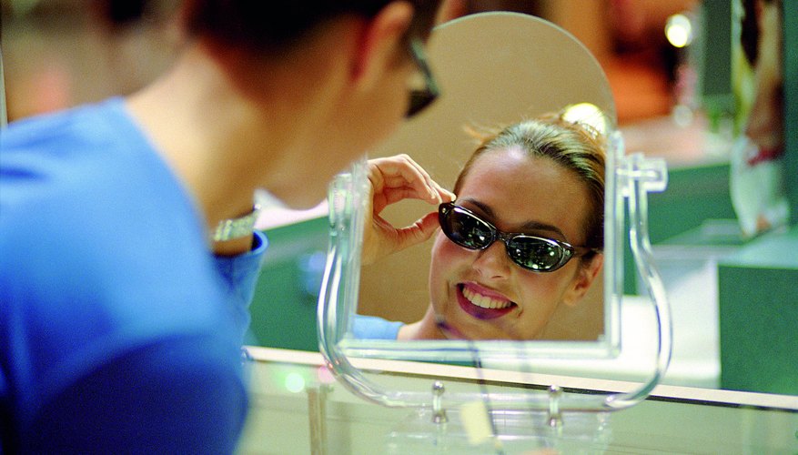 Woman trying on a pair of sunglasses.