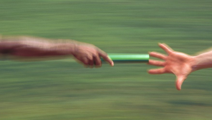 Close up of baton being handed off in a relay race.