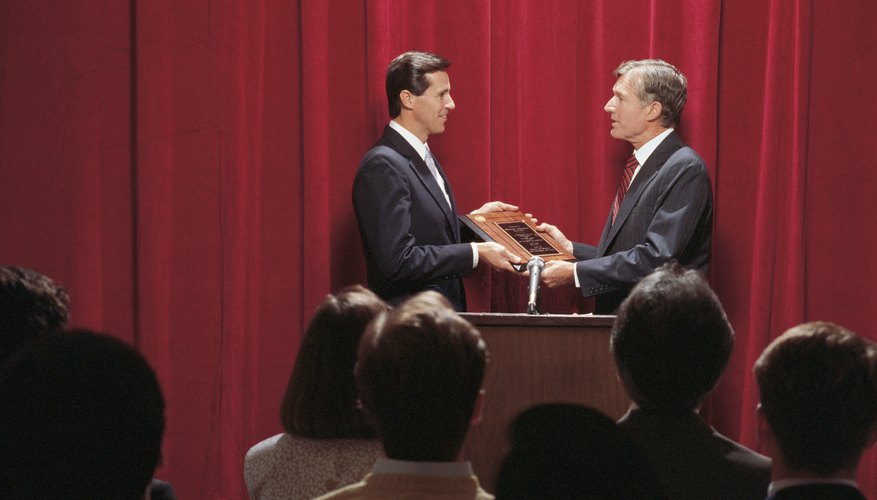 A man is handing someone a plaque.