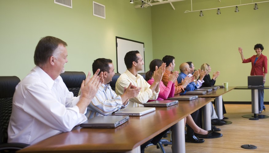 Businessmen applauding conference speaker.