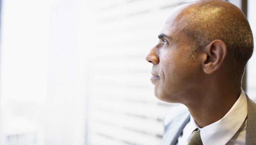 A close-up of a man looking out a window.