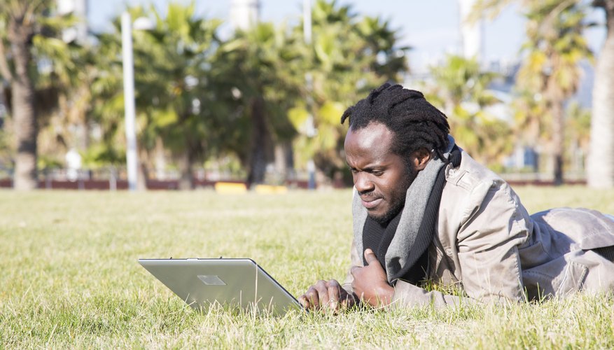 A student is using his laptop outside.