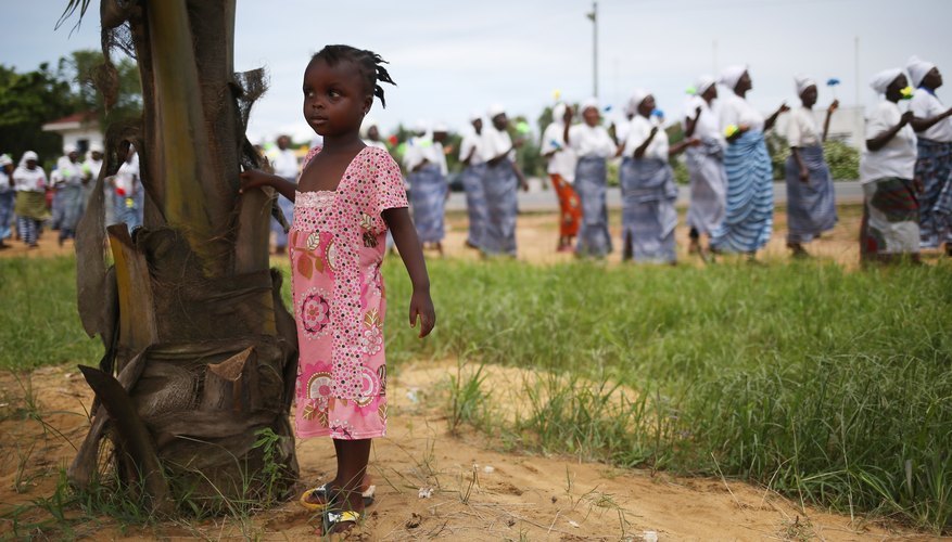 Girl standing next to tree in village