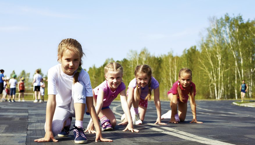 Young kids are lined up to run on a track.