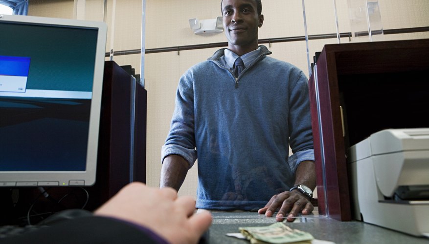 The bank teller requires your signature to cash or deposit a check.