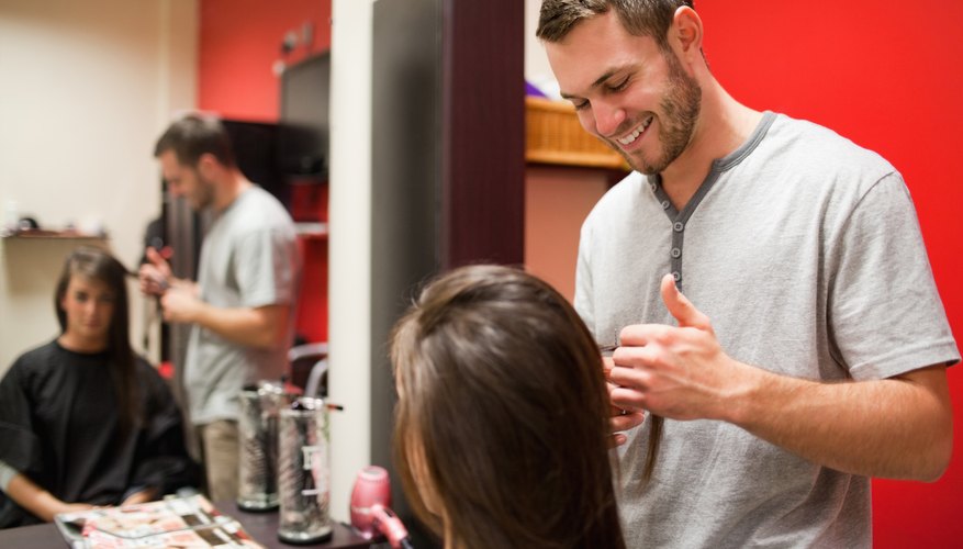 A hair designer talking with his client in a salon.