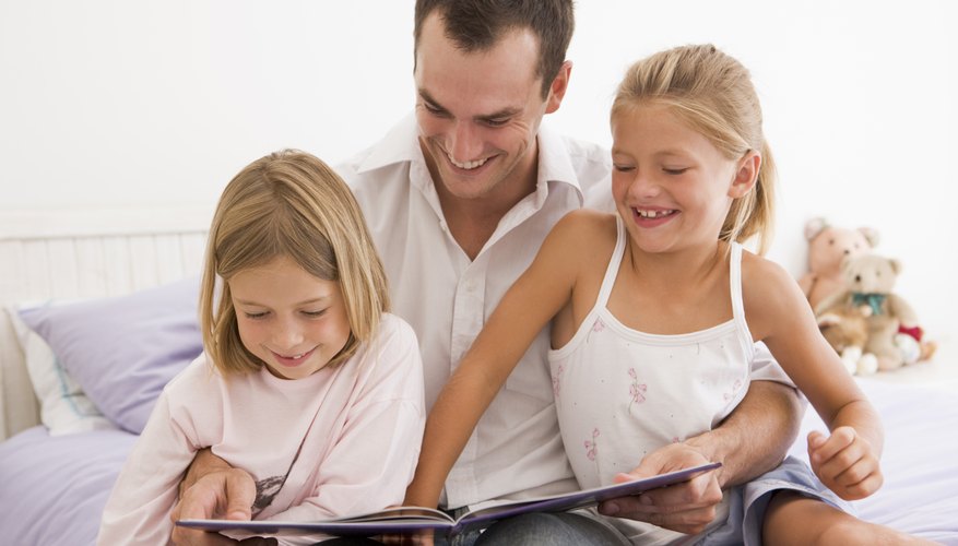 Father reading book with daughters