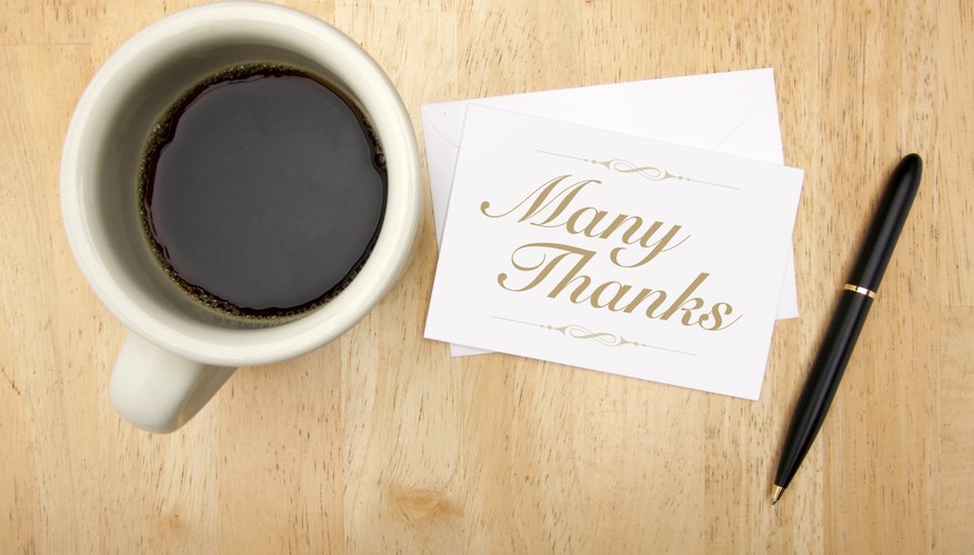 Thank you note and pen next to a cup of coffee