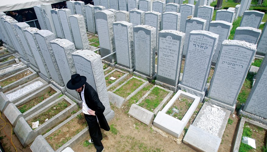 A mourner pays his respects at a Jewish cemetery.