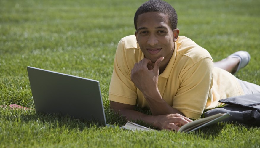Student working outside on laptop.