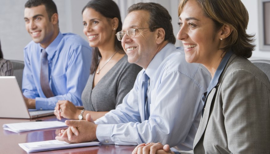 Smiling co-workers at meeting table.