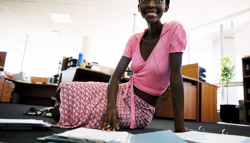 A young woman is doing work in an office.