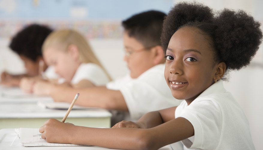 Third grader writing at desk in classroom