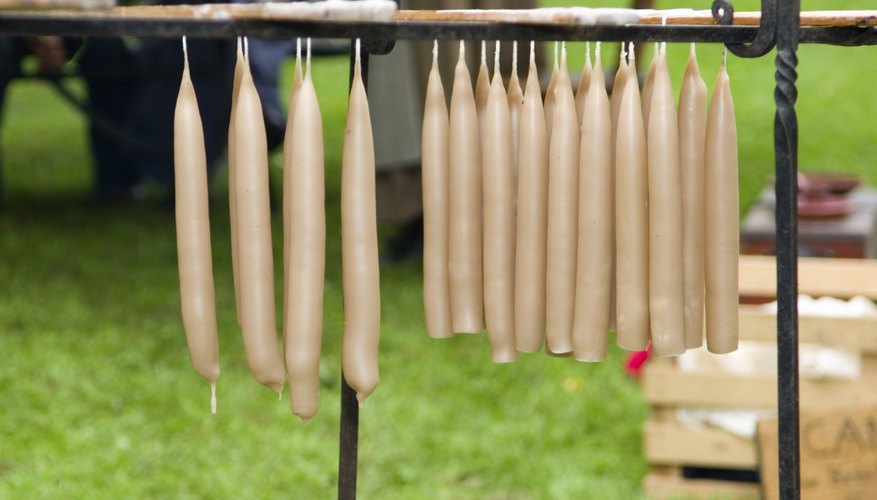Hand-dipped candles drying on a rack.