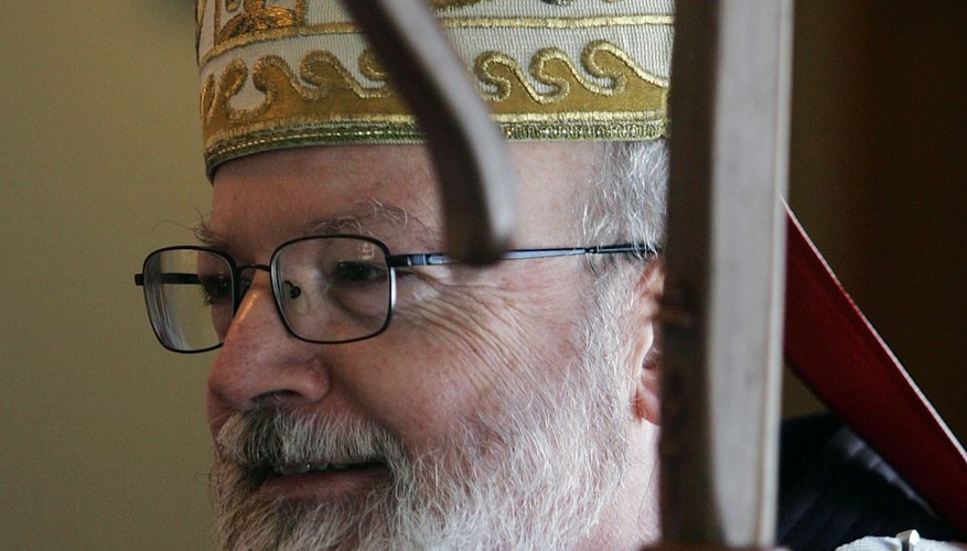 Bishop O'Malley of Massachusetts is wearing a mitre and carrying the traditional bishop's staff, the crosier.