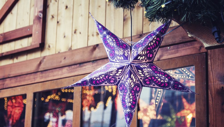 Strings of moravian stars hanging in a rustic storefront.