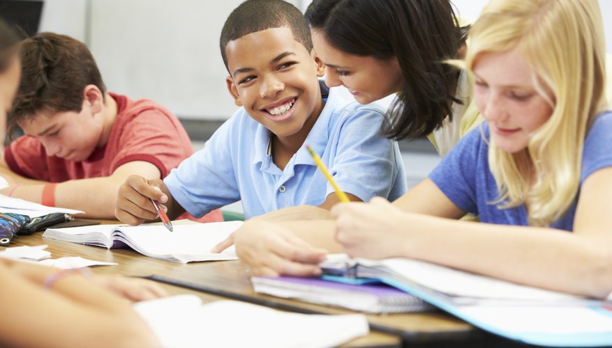 Teacher talking to student in classroom.