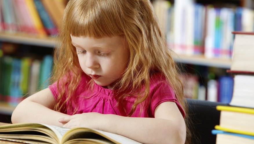 Little girl reading in library