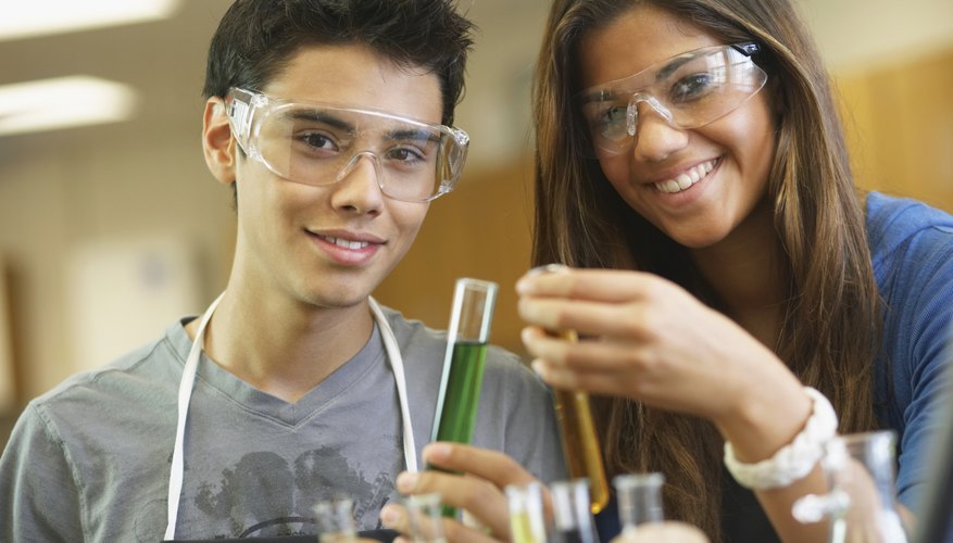 Smiling children conducting chemistry experiment in classroom