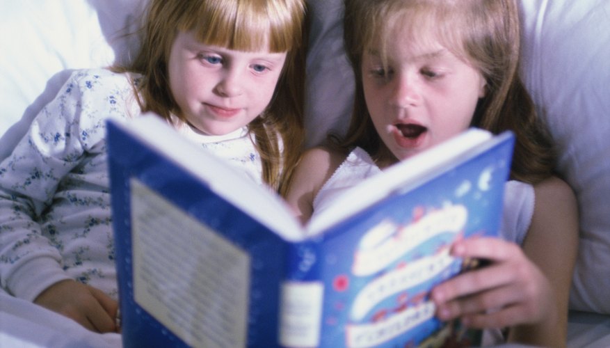 Young children are looking through a picture book.