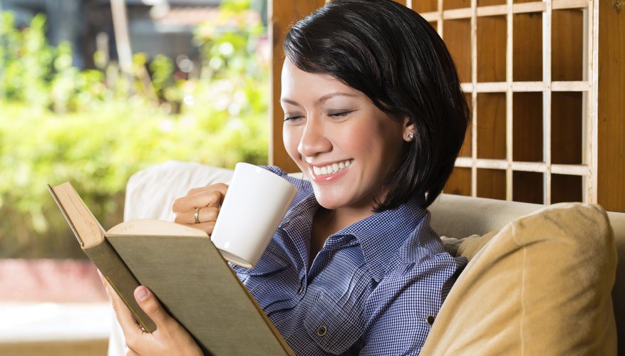 Student reading on couch with cup of tea