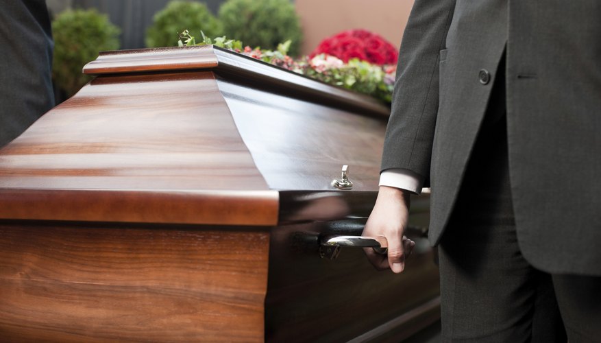 Palm bearers carry a casket.