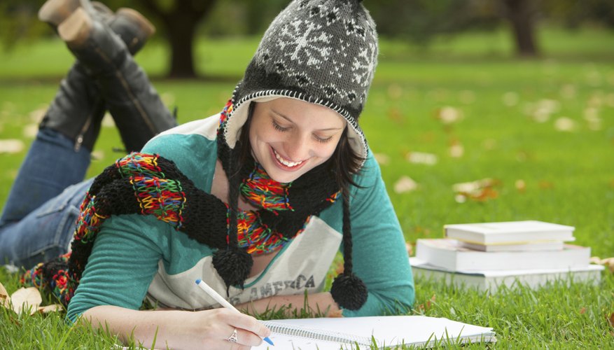 Image of a college student studying on the grass.