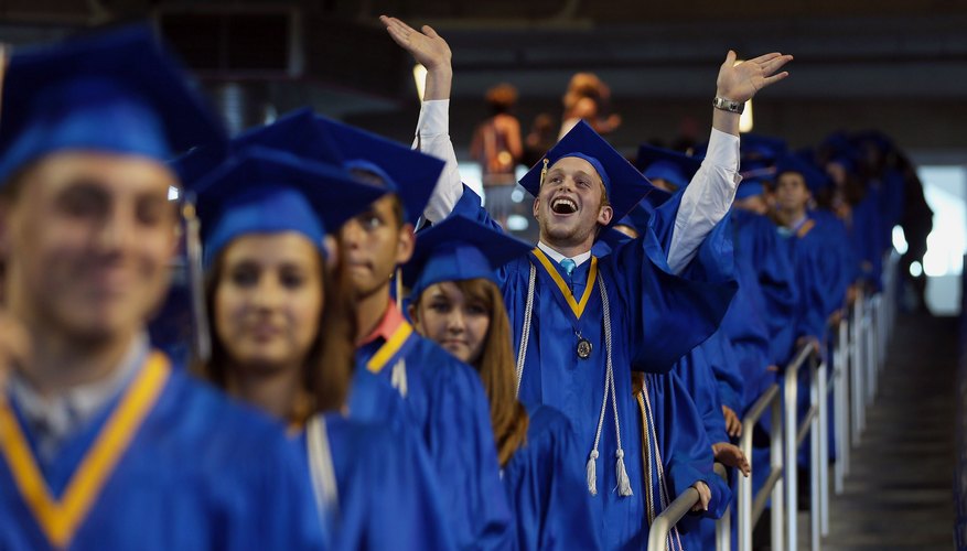 An excited graduate raising his arms to the crowd at commencements.