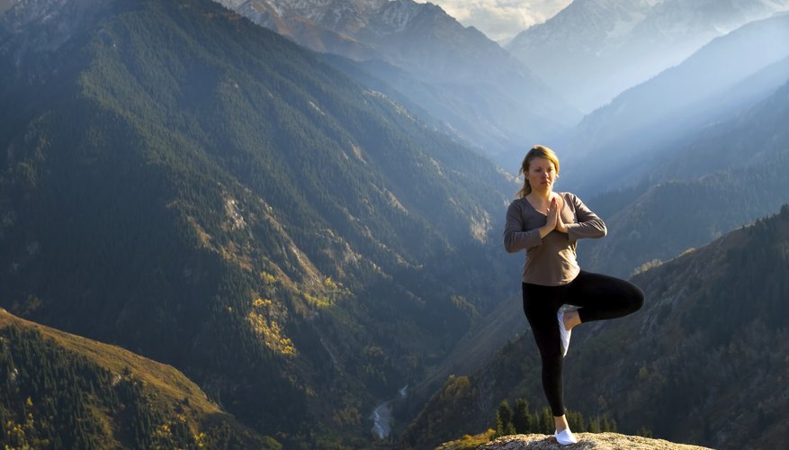 Woman doing yoga on a mountain summit