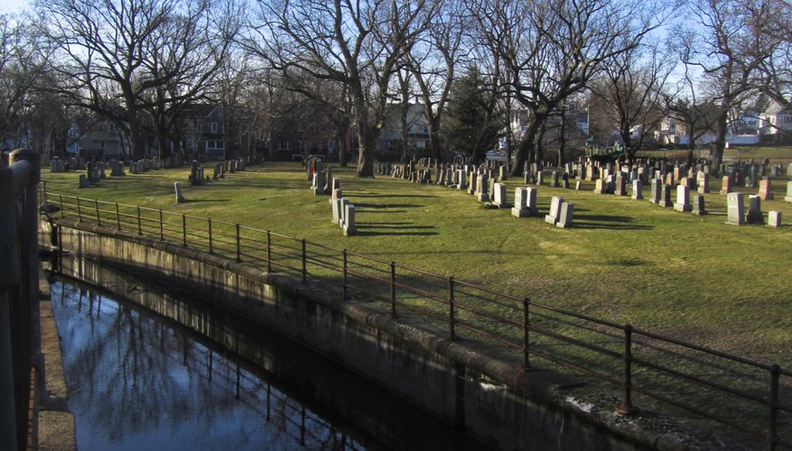 A brook runs along a cemetery.