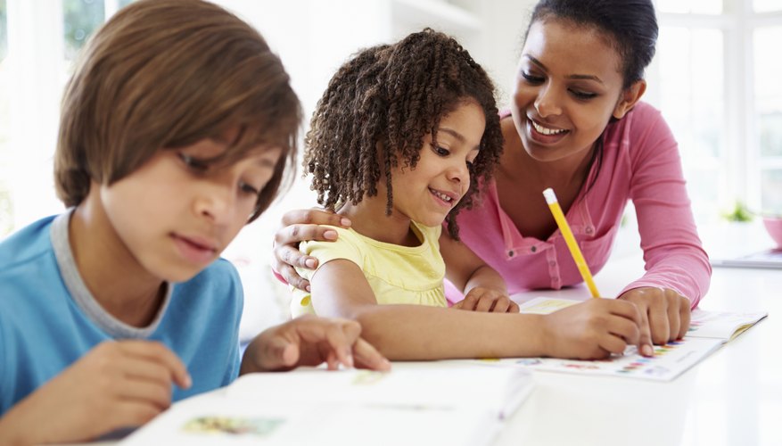EEC Certified teacher helping elementary students with homework in after-school program