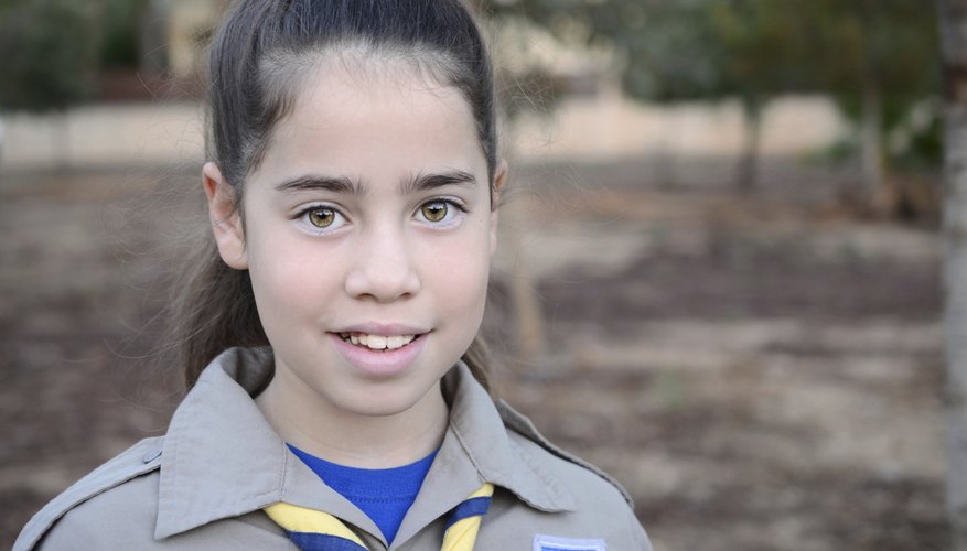 A young girl scout is on her way to camp.