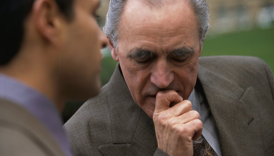 Older man having a serious talk with younger man outside.