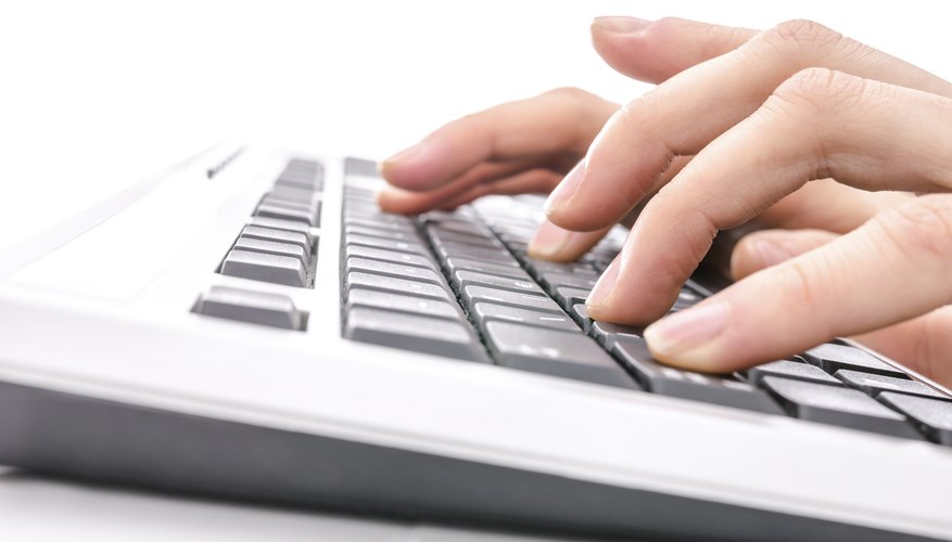 Hands typing on a computer keyboard