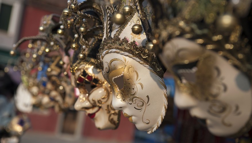Venetian masks on display at an outdoor market.