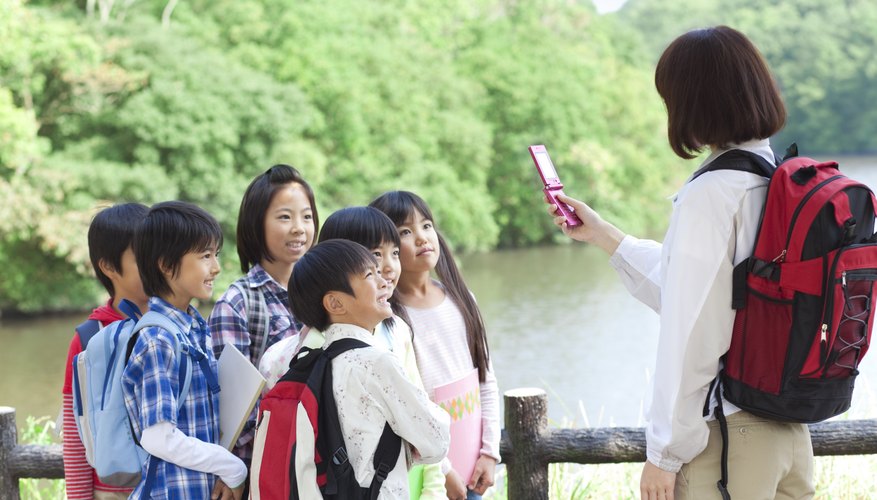 Teacher taking a photo of her students on field trip.