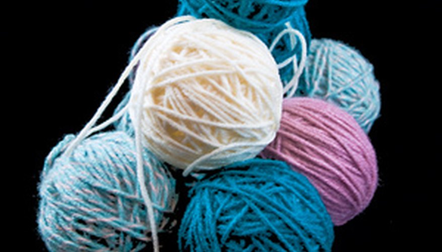 Make buttons using yarn, paint and a paper plate.