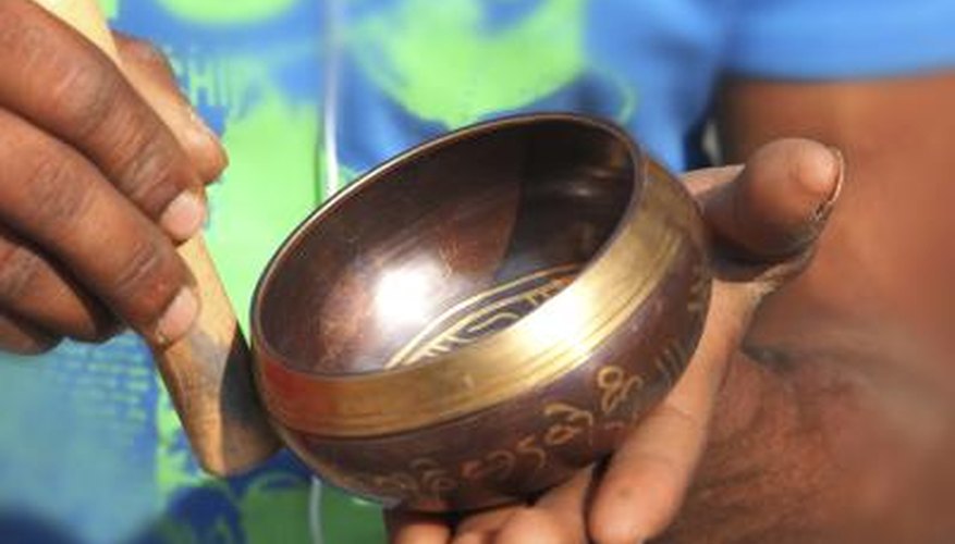 A man makes sounds with a singing bowl.