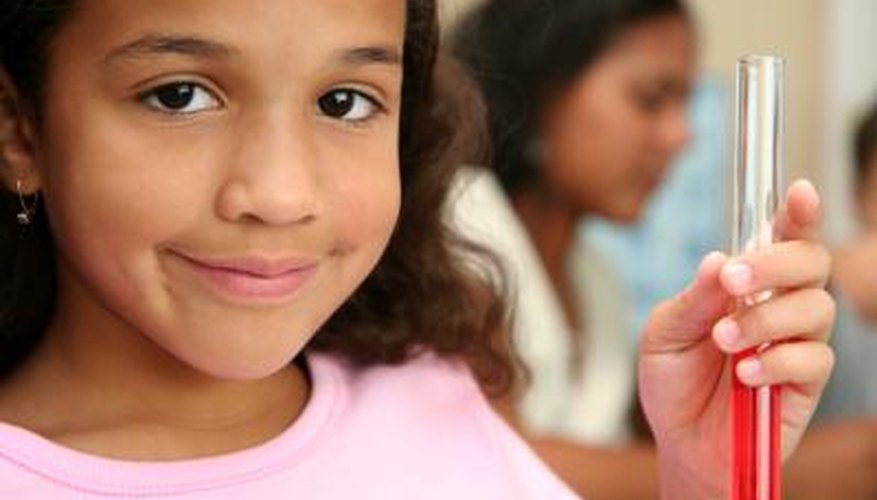 A girl at school holds up a test tube filled with liquid.