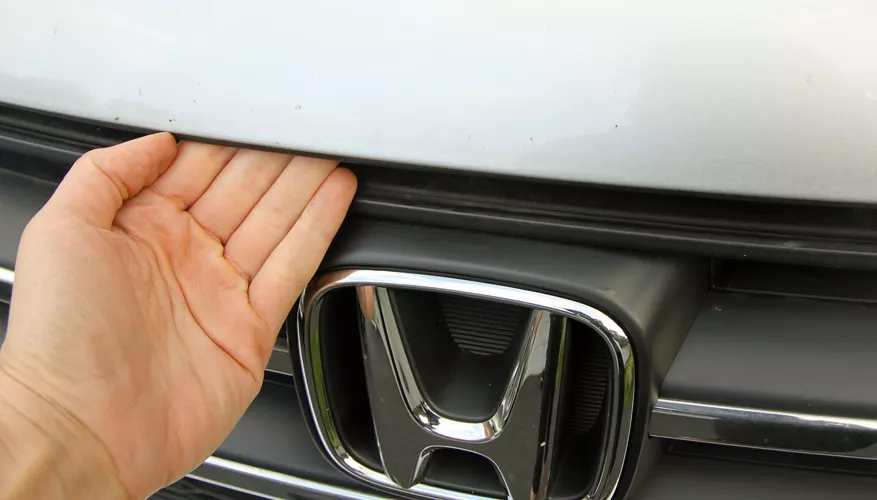 Honda CR V hood latch between the hood and the grille