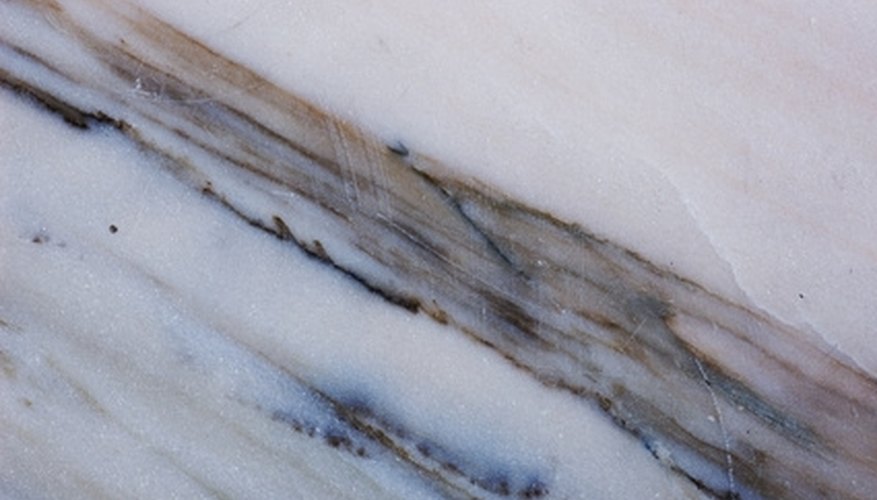 Photo Credit: Natural marble texture image by Andrejs Pidjass from <a href='http://www.fotolia.com'>Fotolia.com</a> Marble has a smoother surface than quartzite.