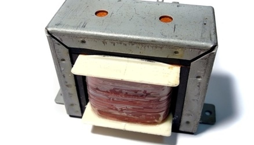 Photo Credit: transformateur électrique image by Lounatiq from <a href='http://www.fotolia.com'>Fotolia.com</a> A step-up transformer increases the voltage while increasing current.